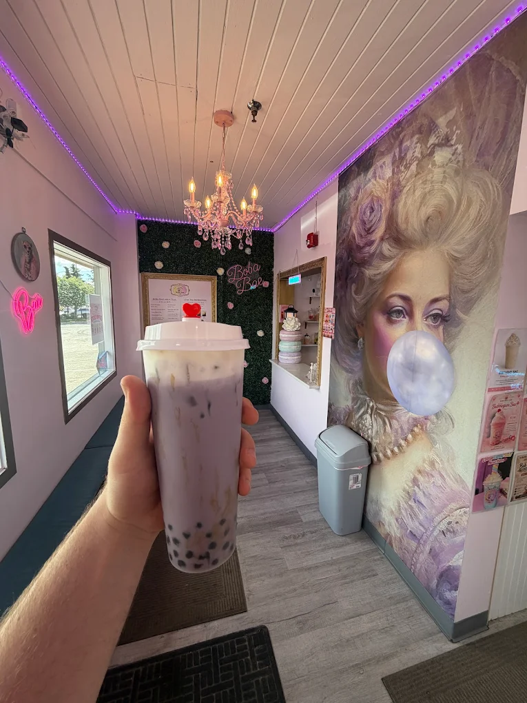 Taro boba cup under the chandelier inside Boba Bae Café